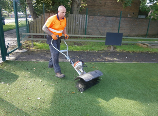 artificial grass maintenance equipment infill perimeter pushed sweeper often held device above around power hand which