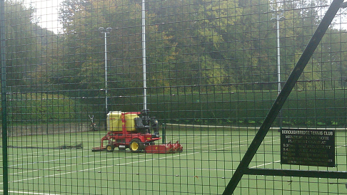 view from behind the fence showing maintenance machine cleaning surface